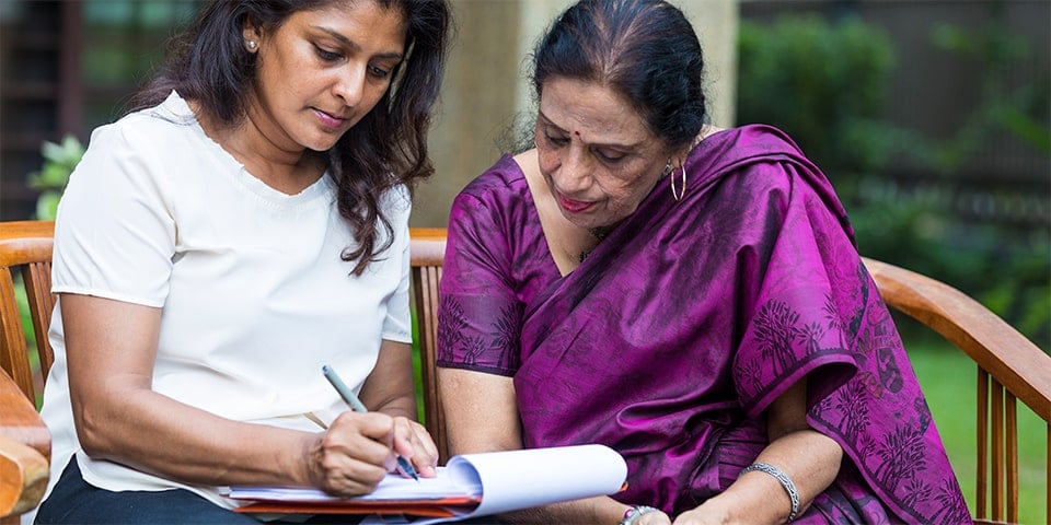 Malaysian mother and daughter going over financial documents.