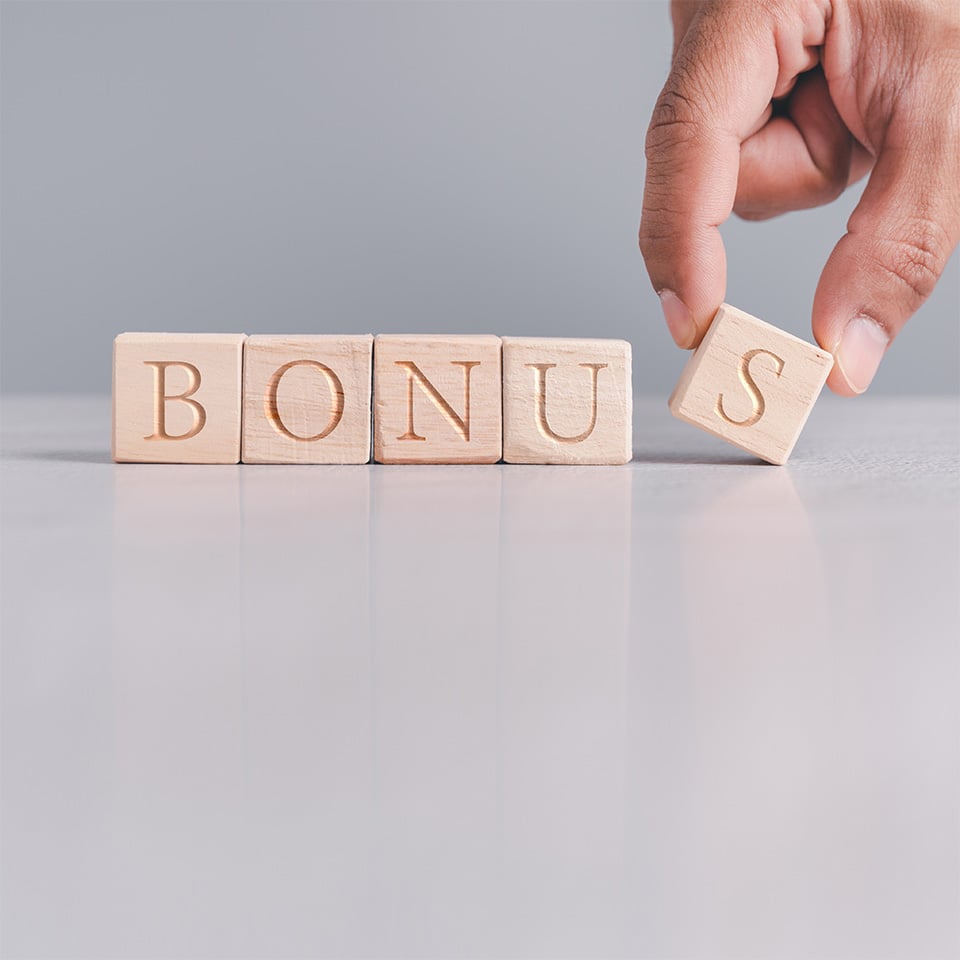 Hand spelling out the word bonus using blocks.