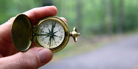 Hand holding a compass.