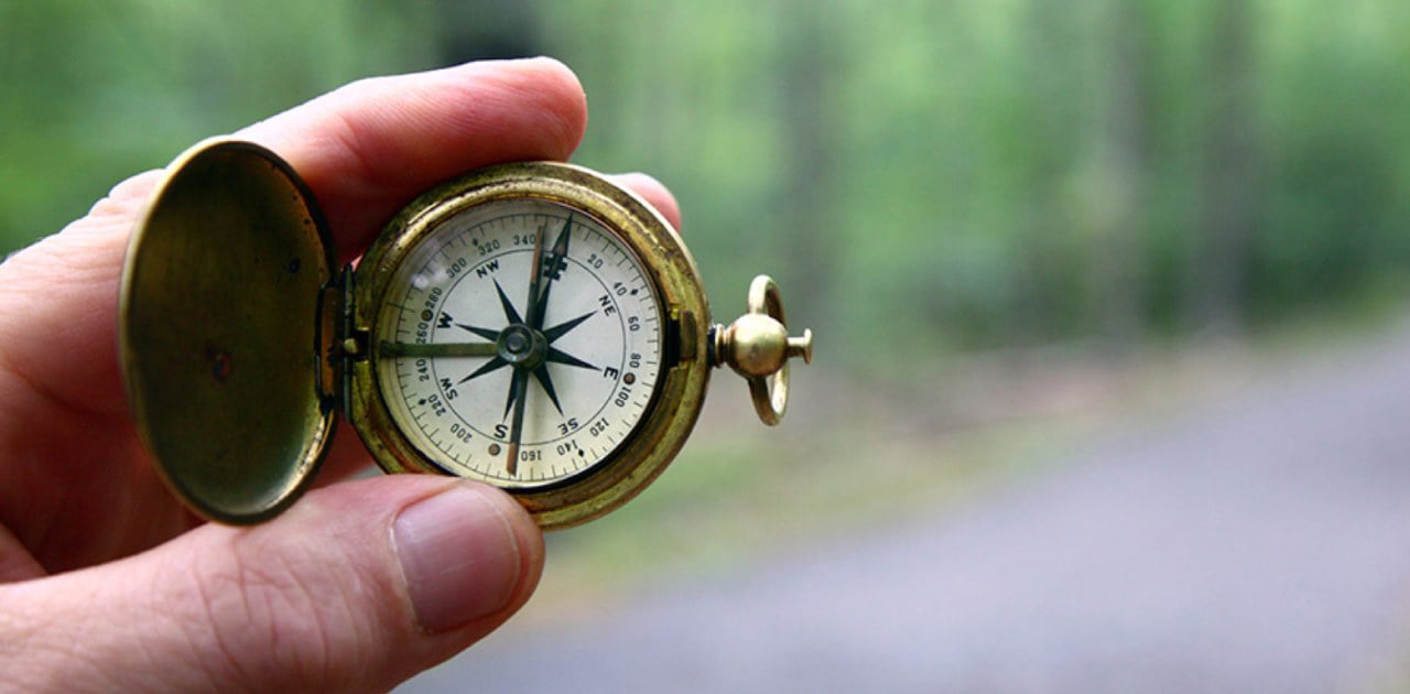 Hand holding a compass.