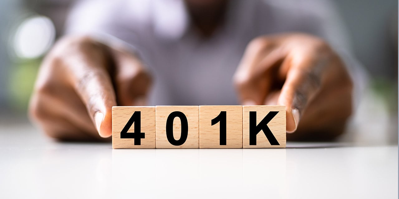 Hands holding wooden blocks spelling out 401K.
