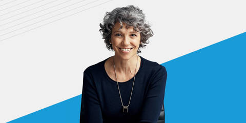Portrait of a smiling woman against a gray and blue background