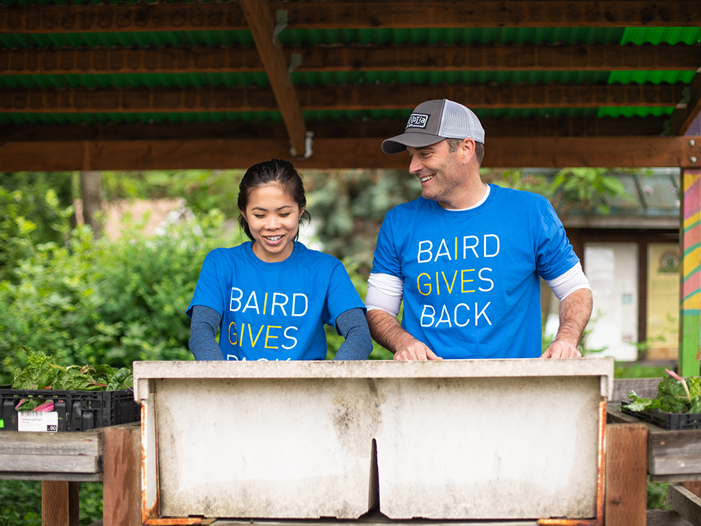 Two Baird Associates working in a garden during Baird Gives Back week