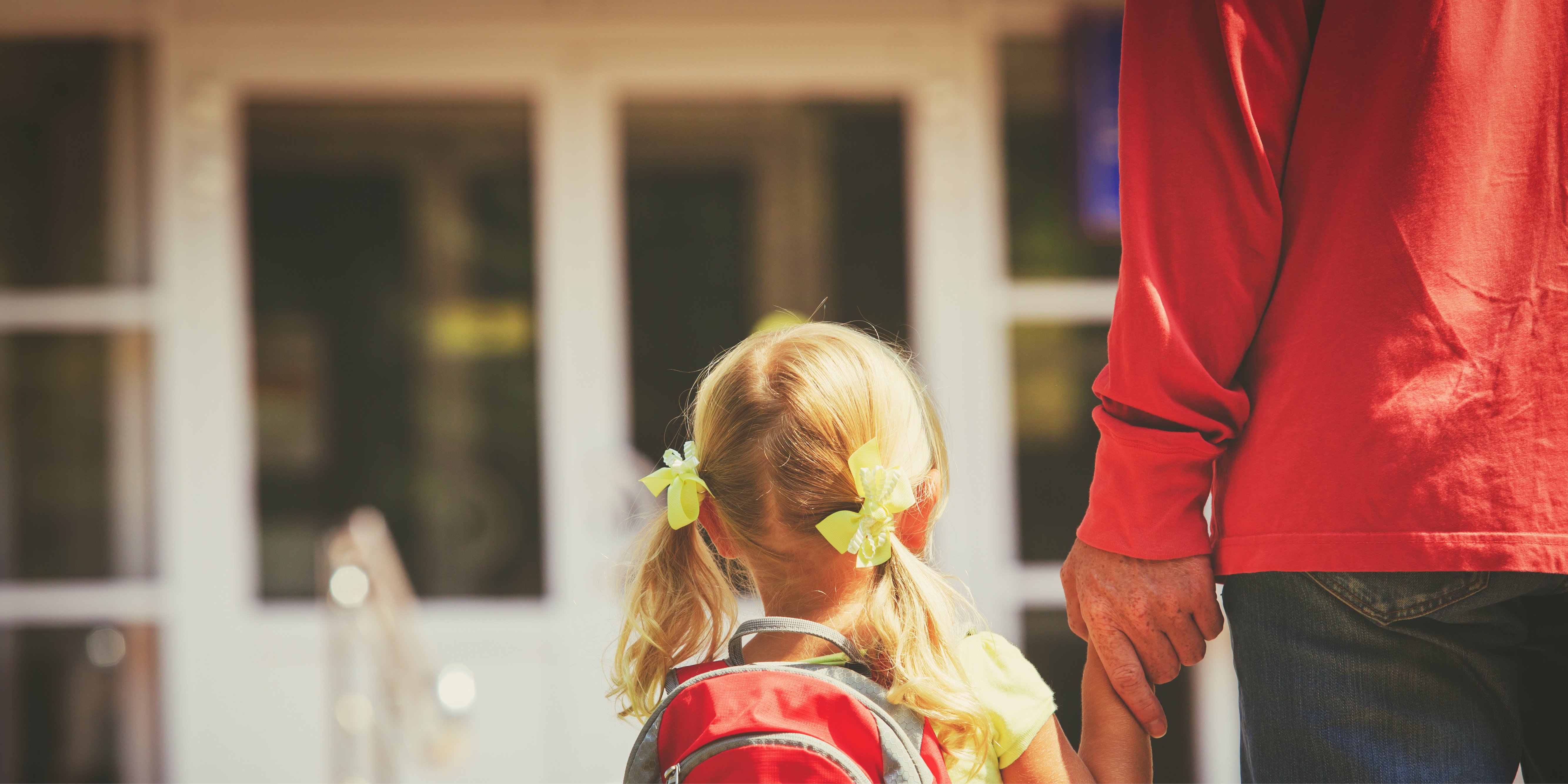 Daughter and parent walking into school