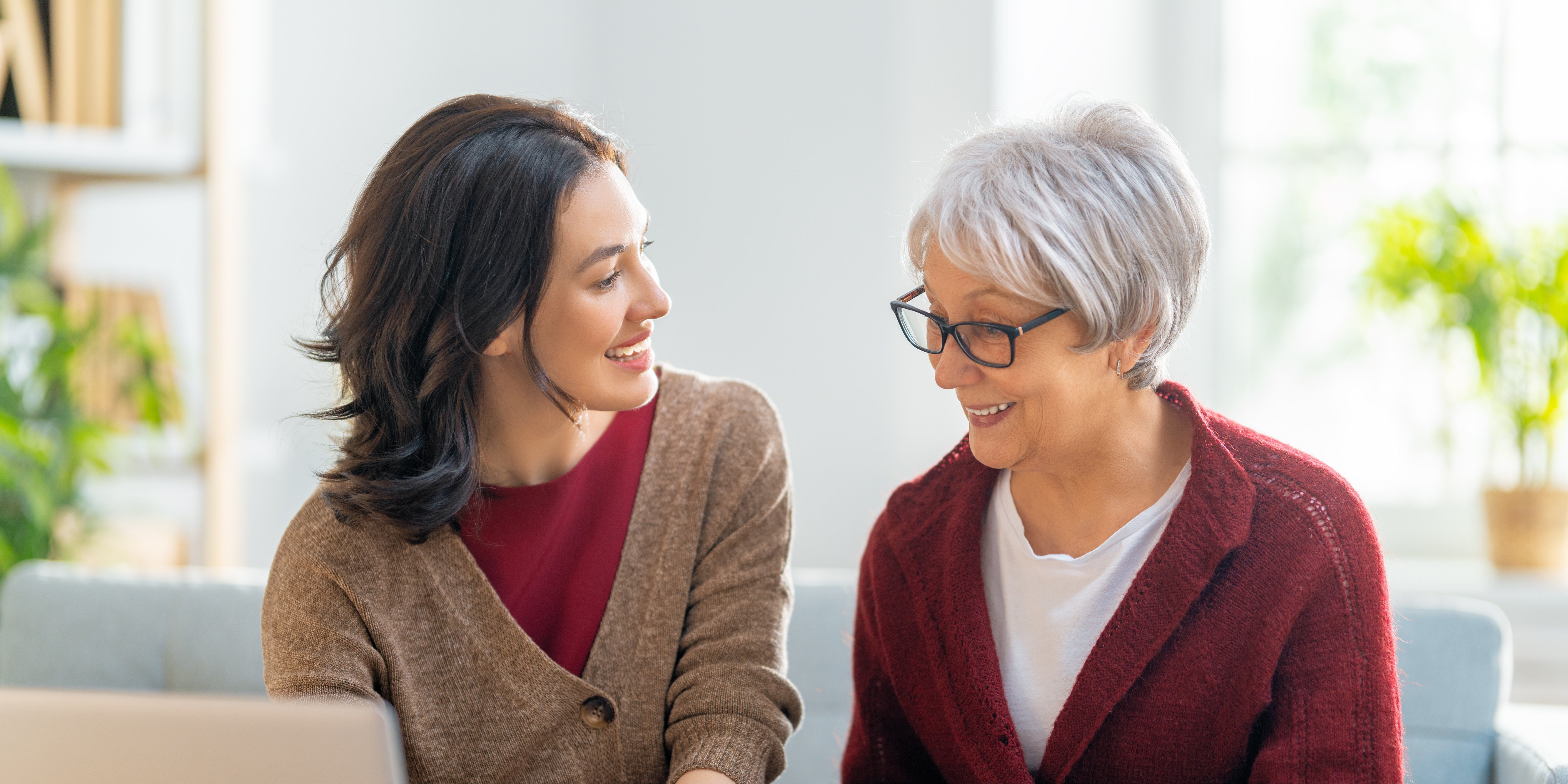 Two generations of women talking while looking at a computer.