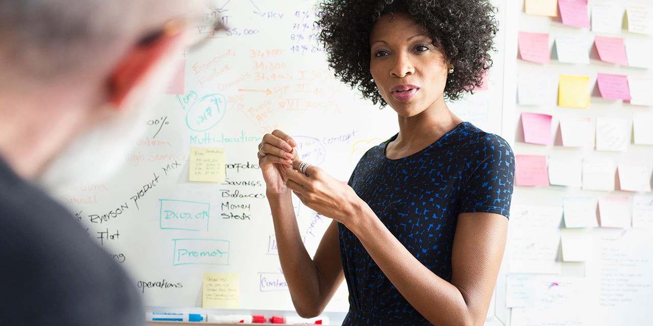 Female executive working at a white board.