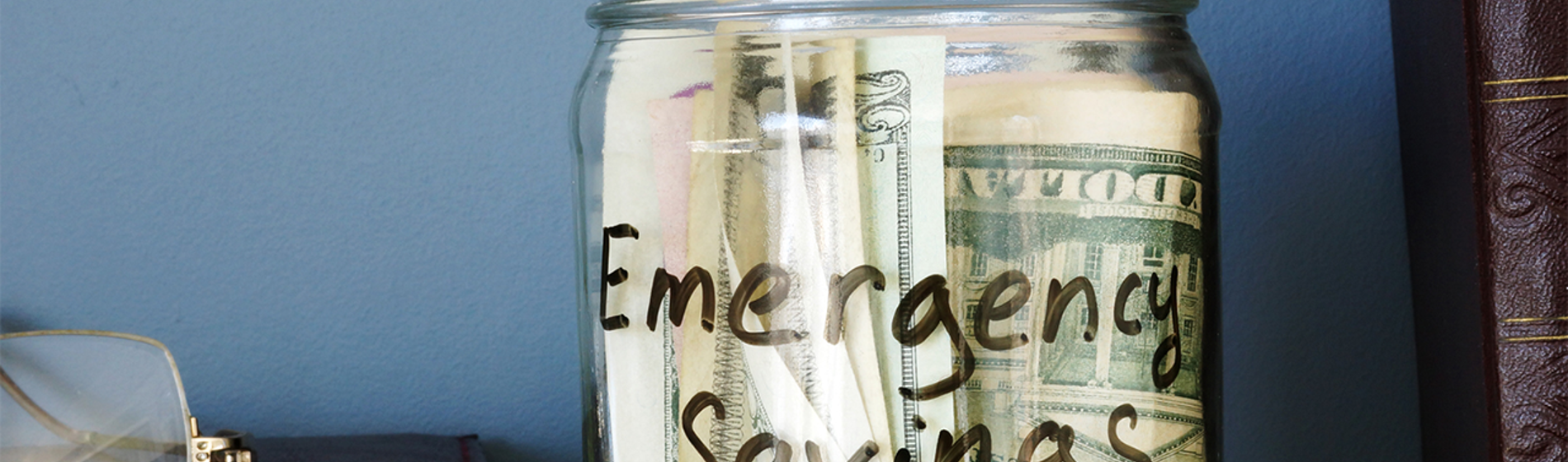 Jar containing money and labeled - Emergency Savings