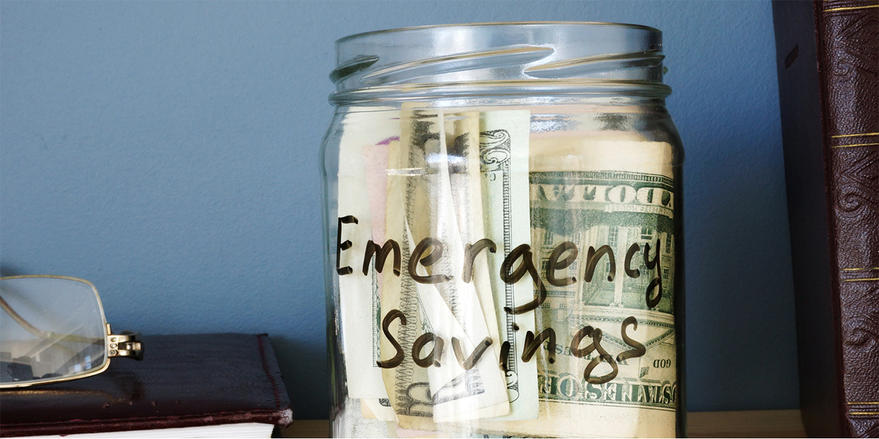 Jar containing money and labeled - Emergency Savings