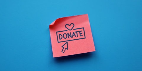 Sticky note with the word donate, a heard and an arrow printed on it.