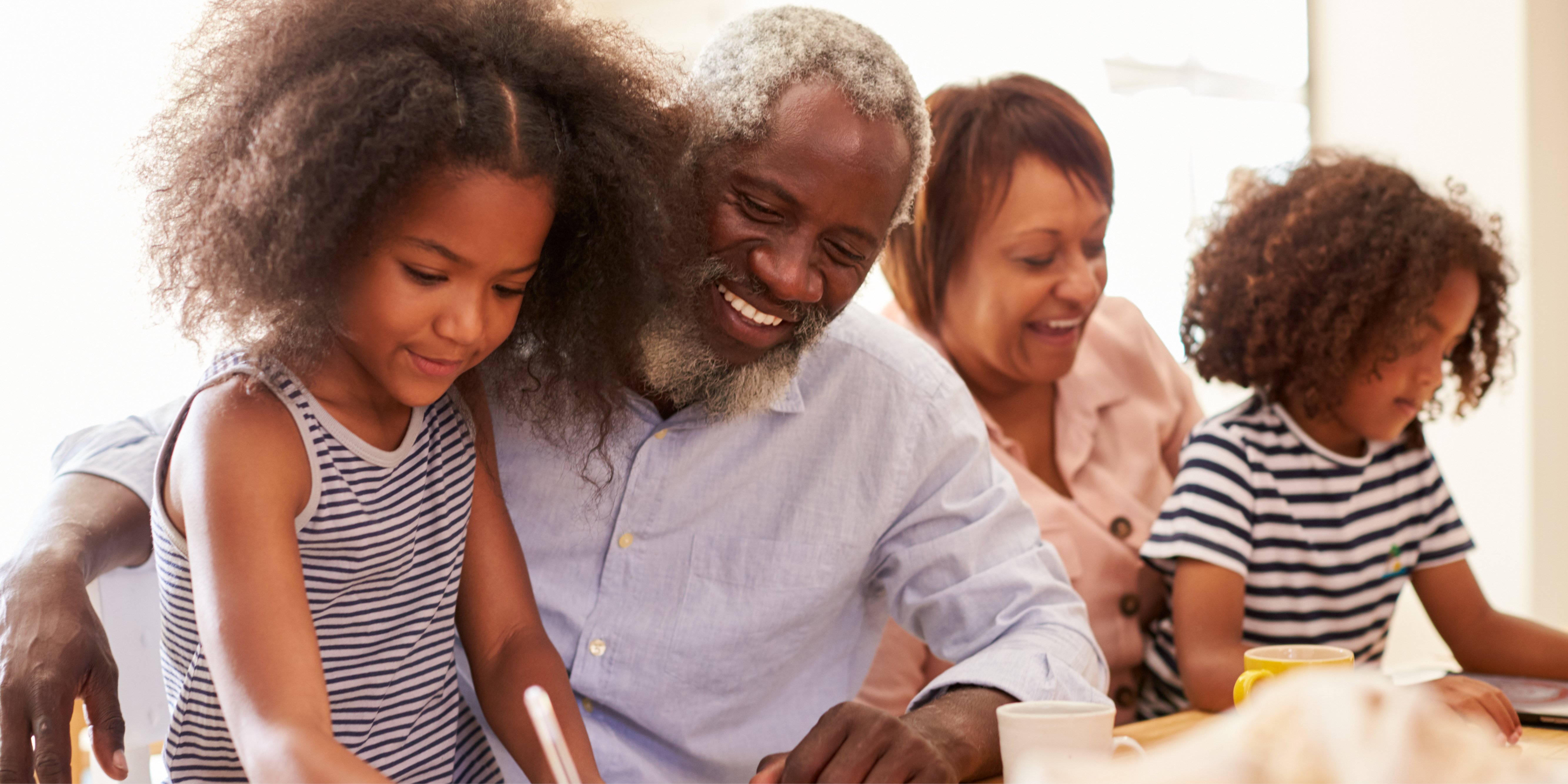 Grandparents playing with grandchildren at a table.