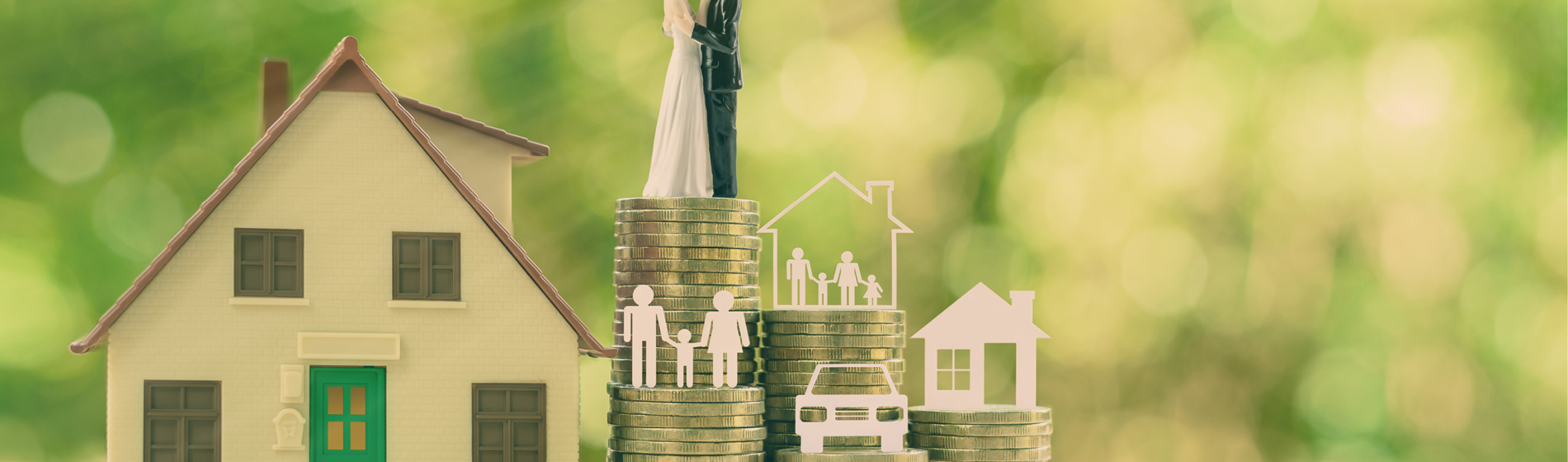 Figures of a bride and groom standing on a stack of coins next to a house