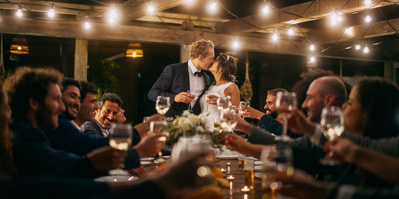 Wedding couple kissing during a toast
