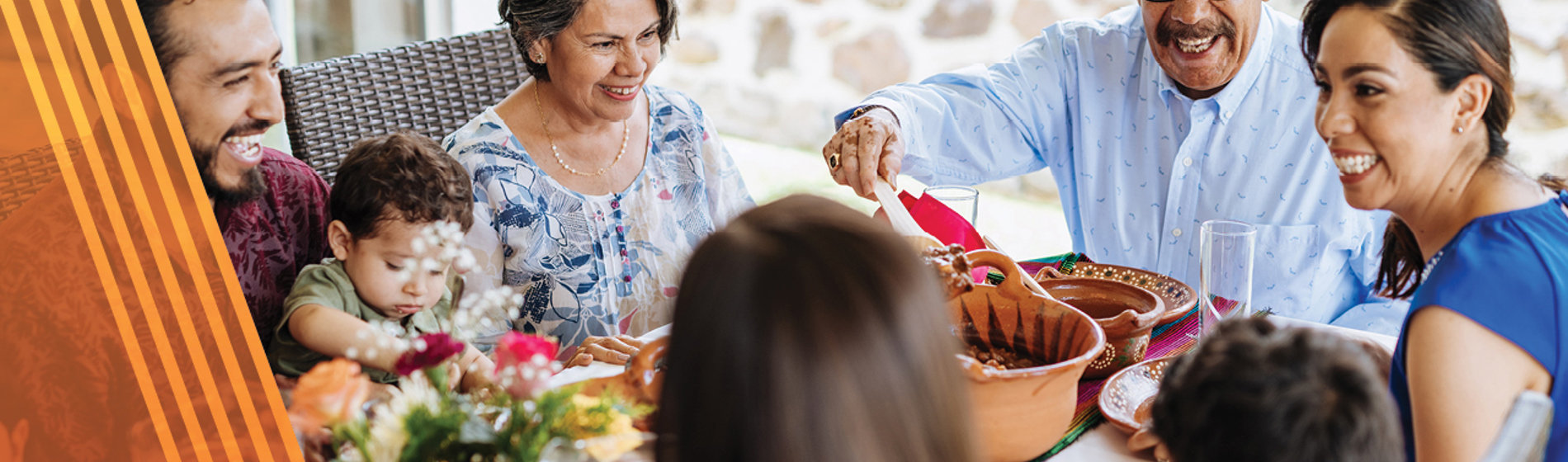 Multigenerational family eating together ad a dining room table.