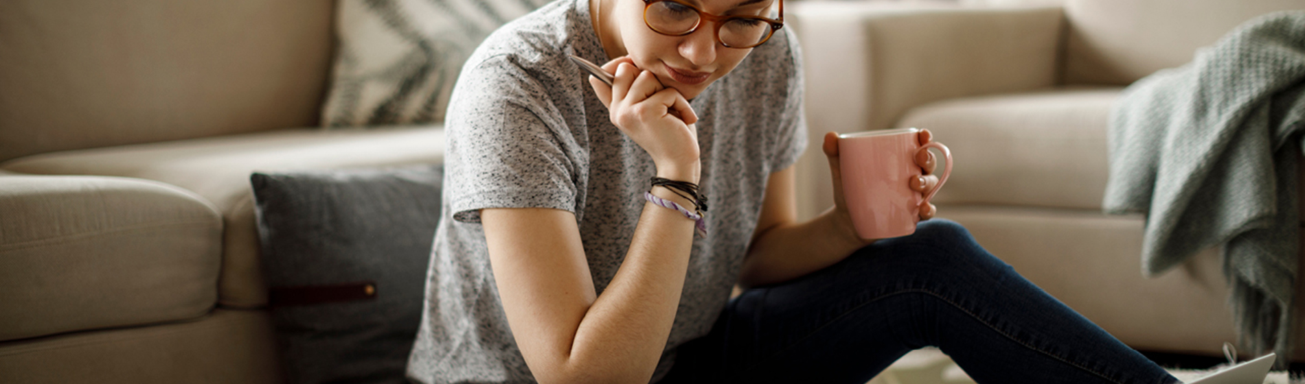 Young adult sitting on the floor doing research.