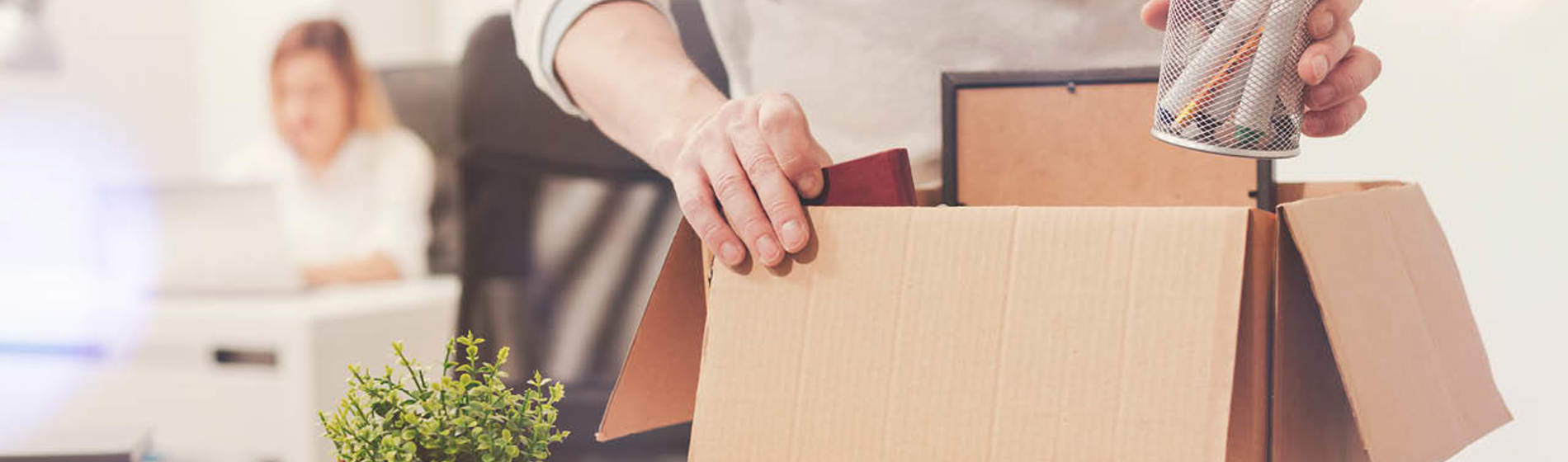 Man packing desk contents into a box.