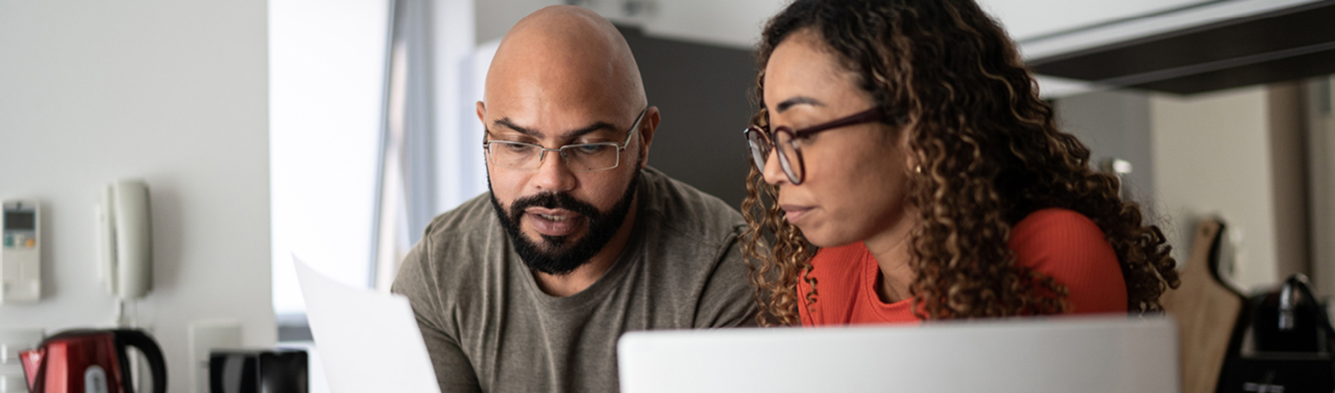 Couple looking at papers and a laptop