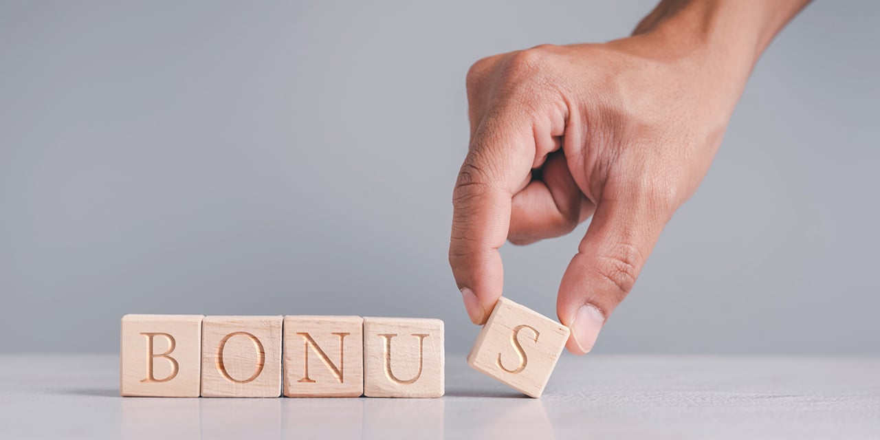 Hand spelling out the word bonus using blocks.