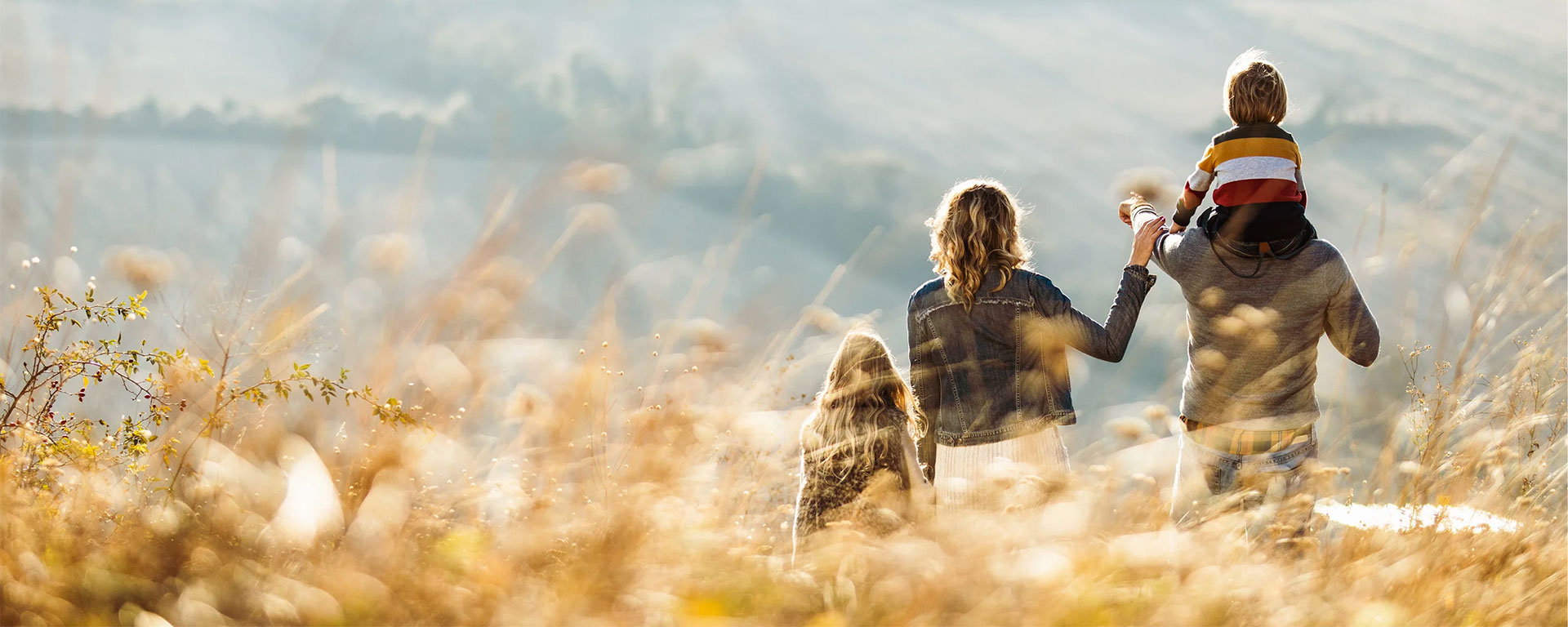 Young family walking through a field.