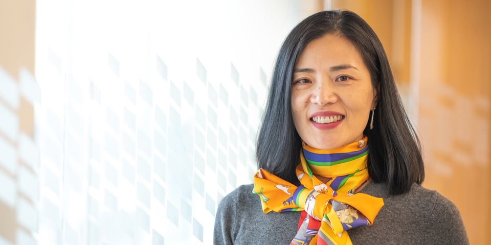 Photo of professional woman standing next to glass wall