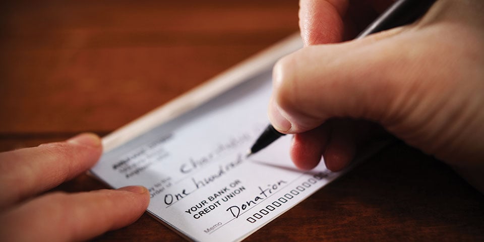 Individual writing $100 check to undisclosed charity.