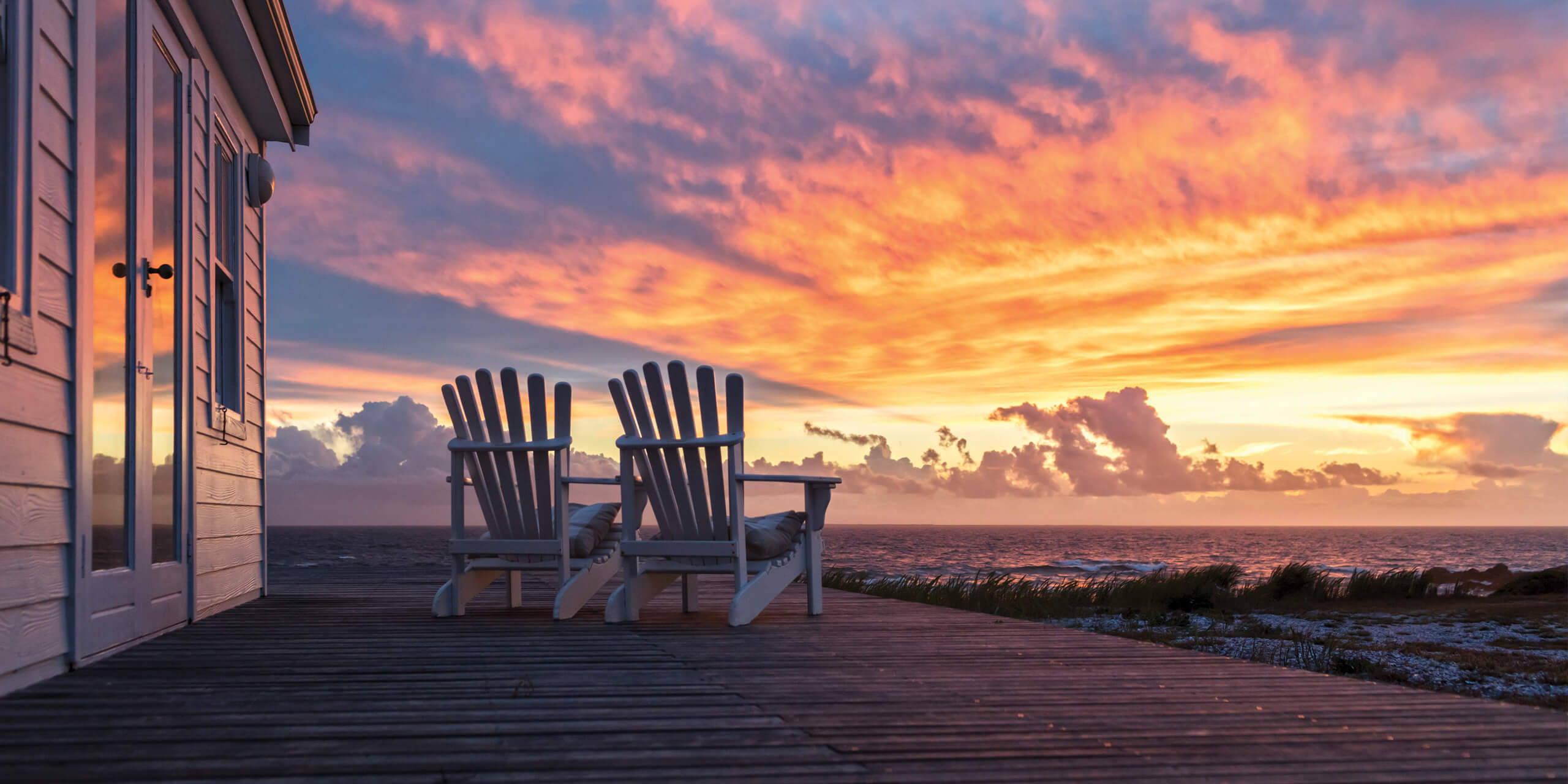 Two Empty Chairs Facing Magnificent Sunset View at Beach