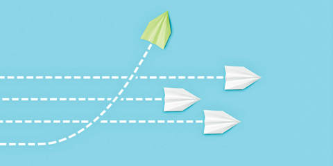 Green paper airplane veering away from white paper airplanes