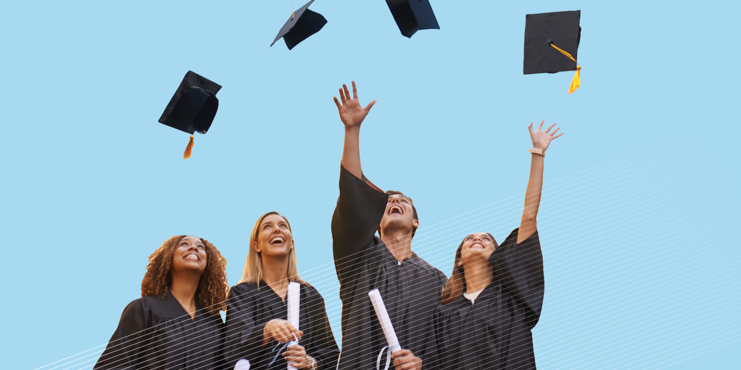 Four graduates throwing their caps in the air