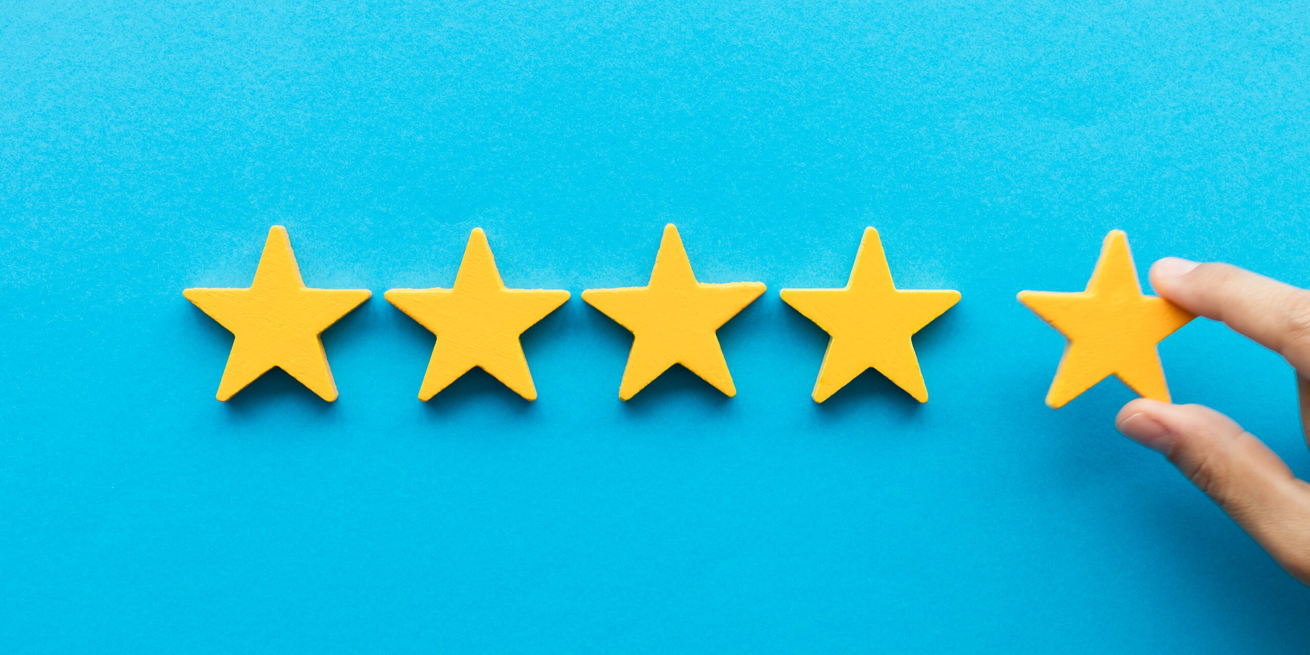 Hand adding a fifth star to a row of stars