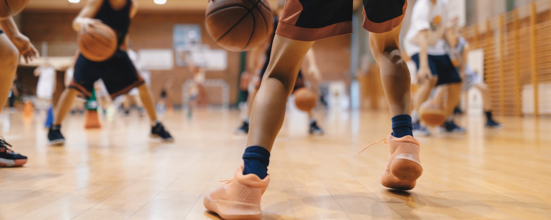 Junior level basketball player bouncing basketball