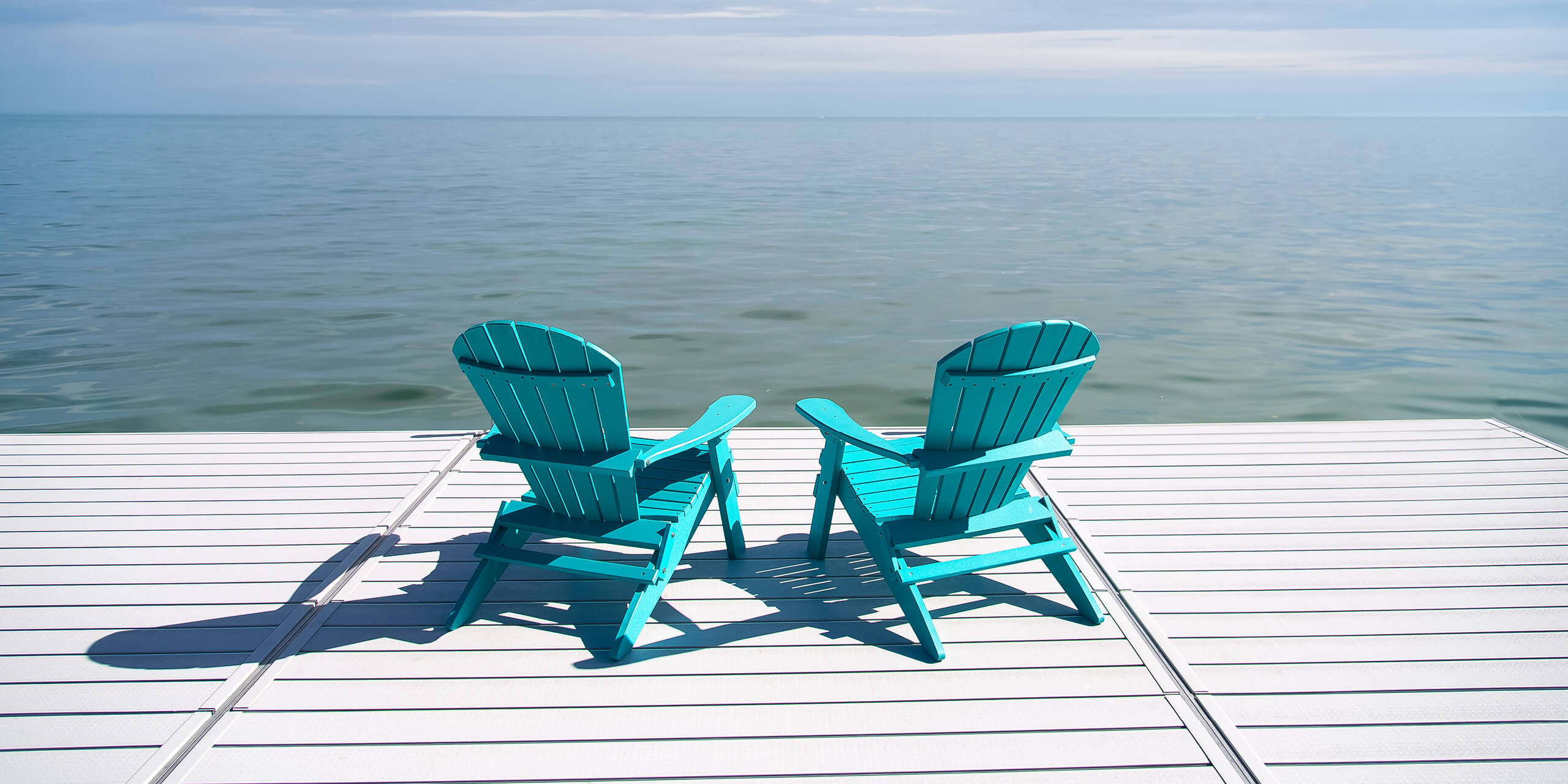 Two adirondack chairs on a dock