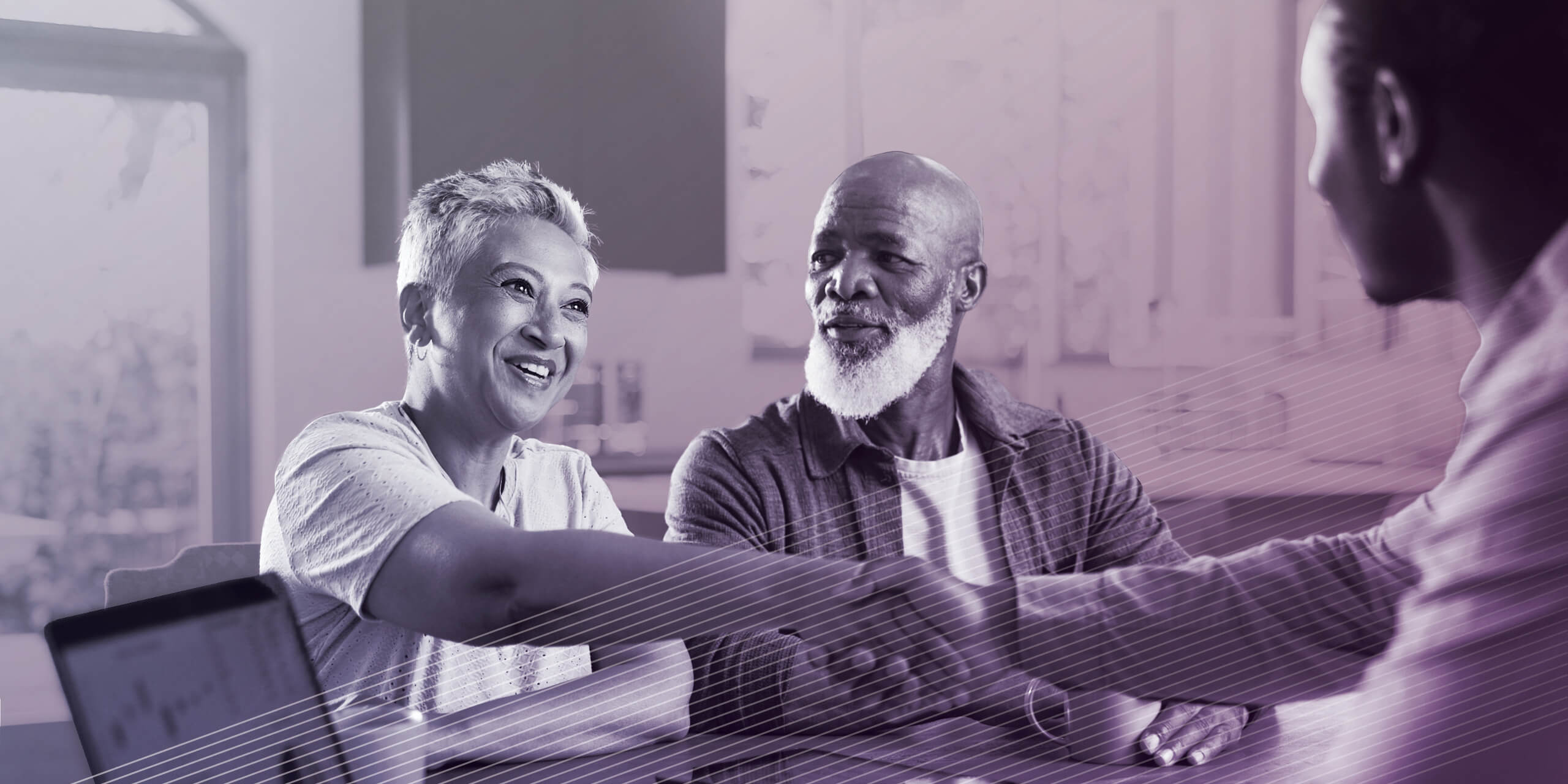 Couple at home shaking hands with financial advisor