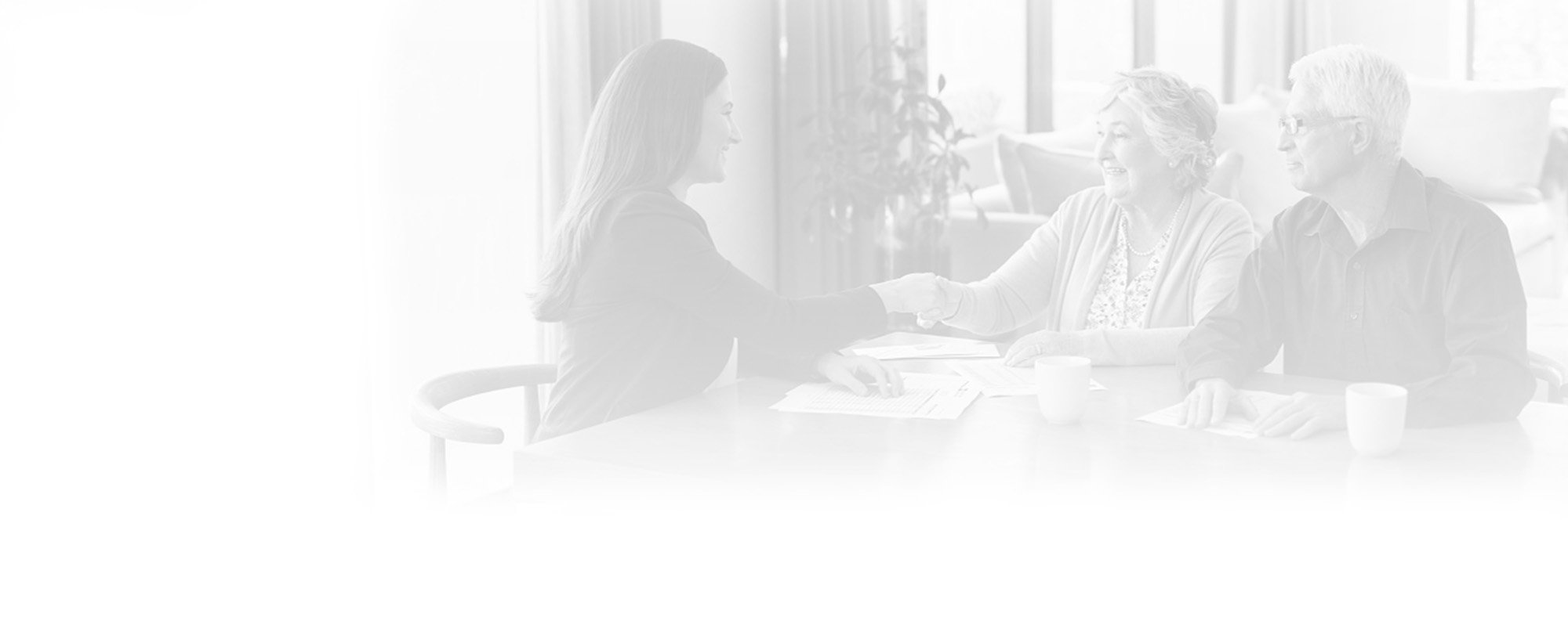 a financial advisor meeting with an older couple in a home setting