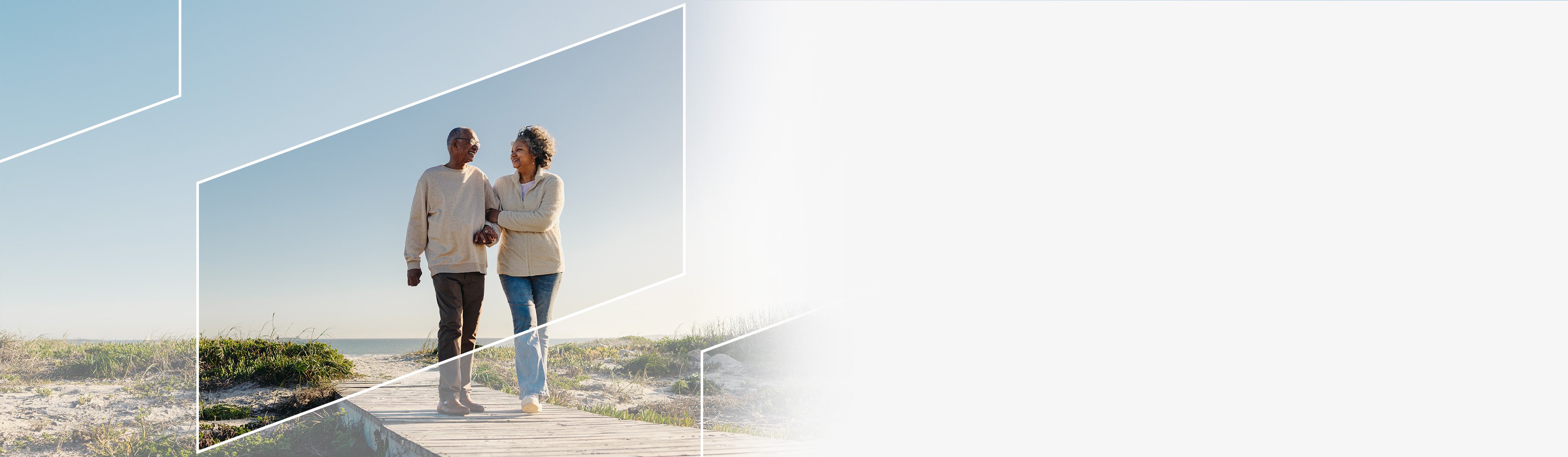 A retired couple walking together along a beach framed in a subtle parallelogram 