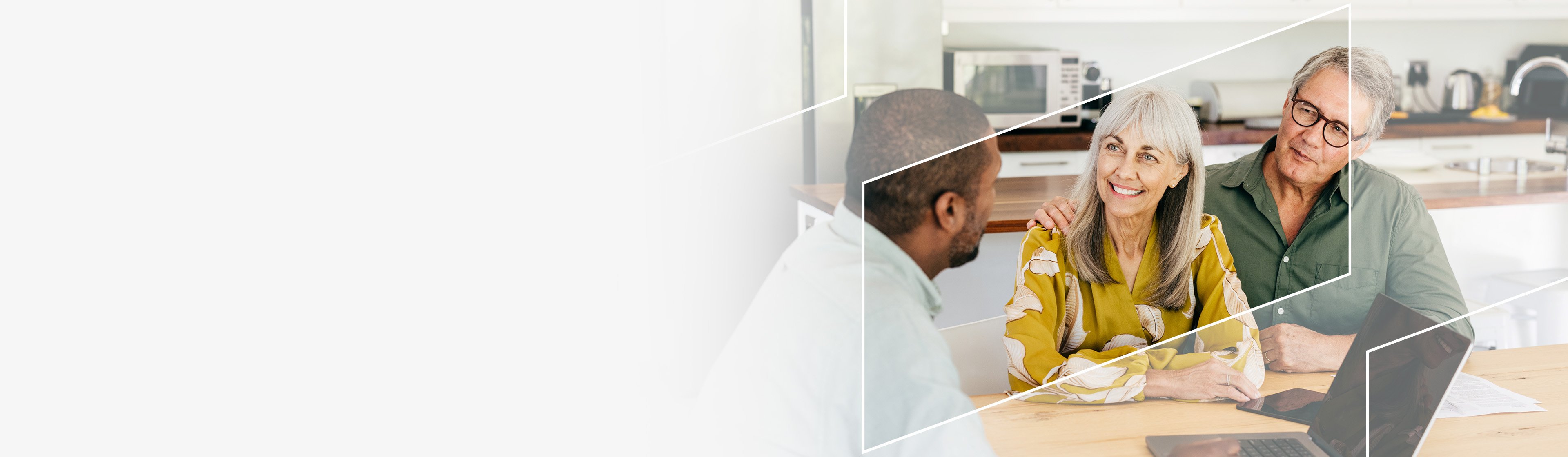 A financial advisor meeting with two clients in a bright modern home setting