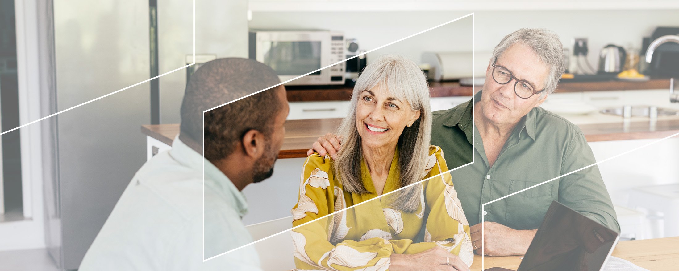 A financial advisor meeting with two clients in a bright modern home setting