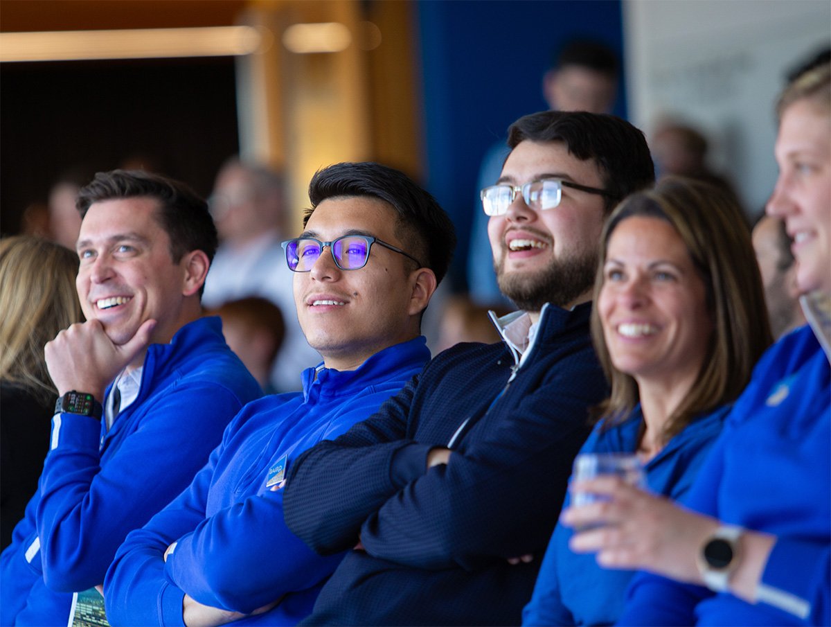 Candid of a group of Baird associates smiling as they listen to a presenter during Baird's annual meeting