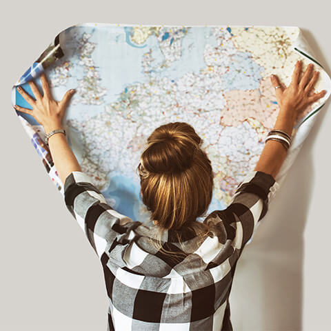 Woman spreading out a map of the world